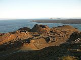 Galapagos 6-2-18 Bartolome Spatter Cone View To Other Spatter Cones and Coast From the top of the spatter cone on Bartolome, we had a sunset view of other spatter cones, with Santiago Island jutting out in the middle and the Bainbridge Rocks beyond.